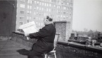 15. Ο Τόφαλος στην ταράτσα τού σπιτιού του, κρατάει την ελληνοαμερικάνικη εφημερίδα με κύριο άρθρο την απελευθέρωση της Αθήνας, 1945
